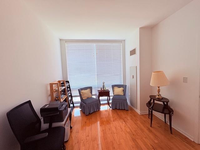 living area featuring light wood-type flooring, an office area, and baseboards