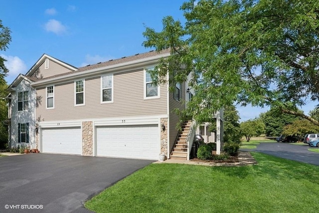 33 Johnson Ct Unit 0, North Aurora, IL 60542 - view of front of house with an attached garage, driveway, stone siding, a front yard, and stairs
