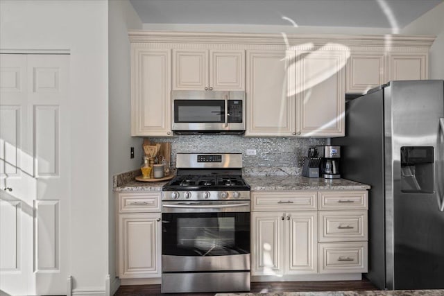 33 Johnson Ct Unit 0, North Aurora, IL 60542 - kitchen with appliances with stainless steel finishes, cream cabinetry, tasteful backsplash, and light stone countertops