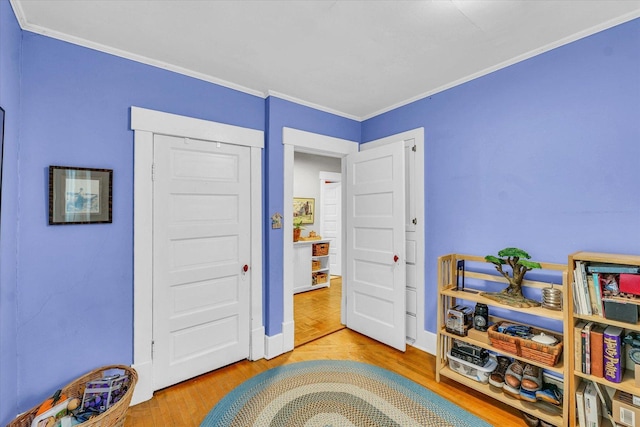 playroom featuring crown molding, baseboards, and wood finished floors