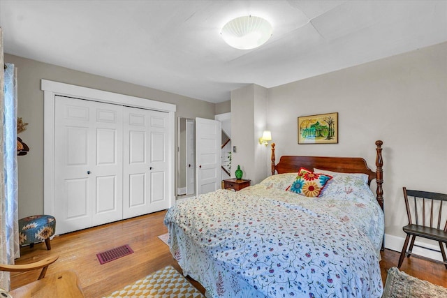 bedroom with wood finished floors and a closet