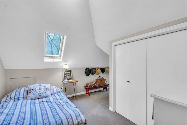 bedroom with carpet flooring, a skylight, baseboards, vaulted ceiling, and a closet