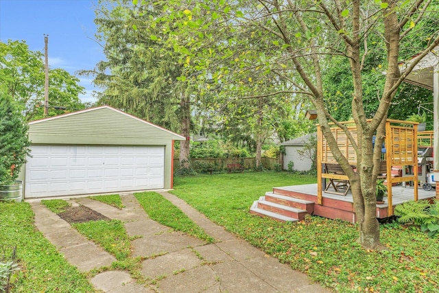 view of yard featuring a deck, an outdoor structure, and a detached garage