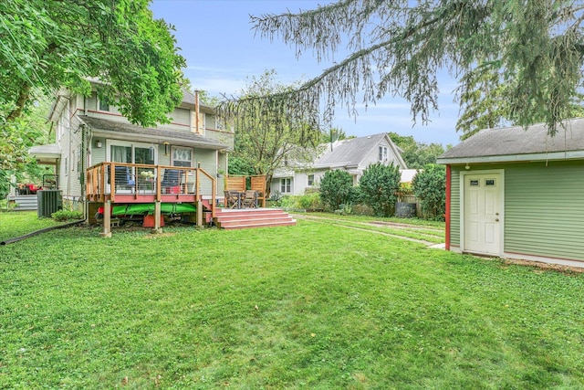 view of green lawn with cooling unit and a wooden deck