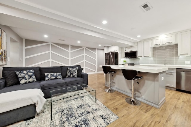 living room with light wood-type flooring and sink