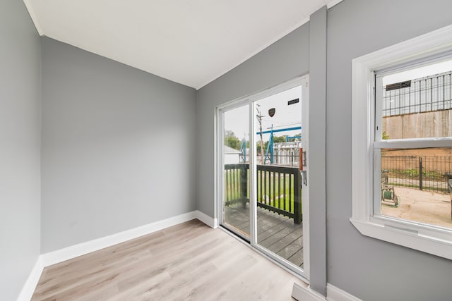 doorway to outside with light hardwood / wood-style flooring and lofted ceiling