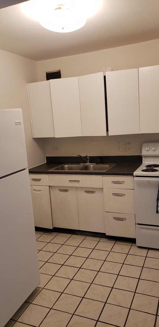 kitchen with sink, white cabinets, white appliances, and light tile patterned floors