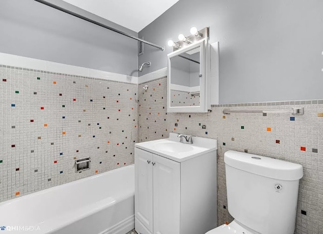 full bathroom featuring shower / washtub combination, toilet, vanity, and tile walls