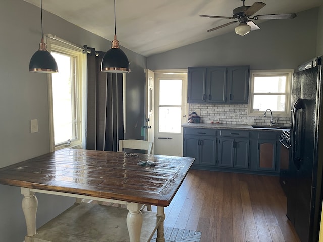 kitchen with ceiling fan, black fridge with ice dispenser, vaulted ceiling, tasteful backsplash, and decorative light fixtures