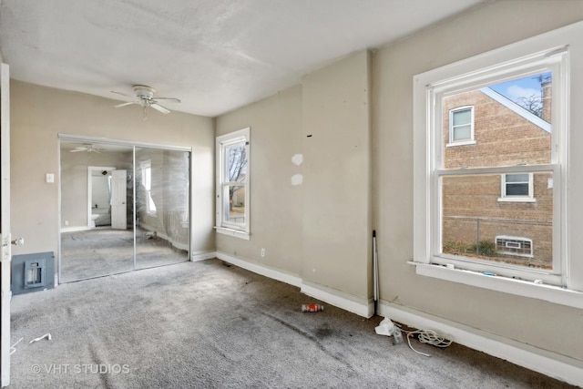 unfurnished bedroom with ceiling fan, carpet floors, multiple windows, and a closet