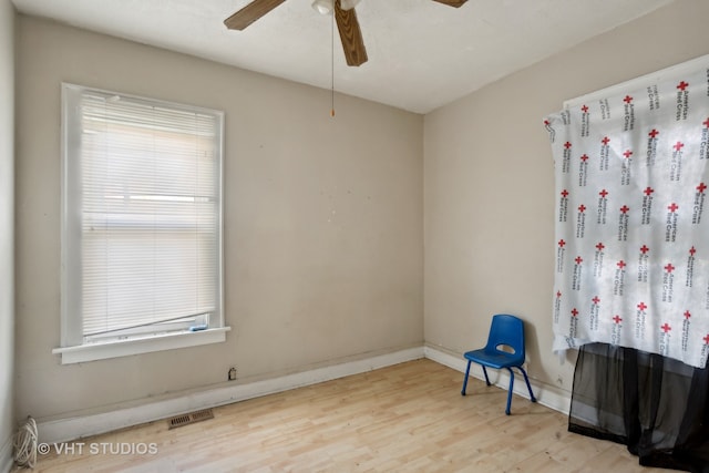 living area featuring light hardwood / wood-style floors, a wealth of natural light, and ceiling fan