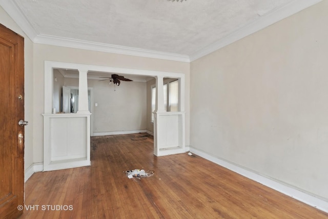 empty room featuring ornamental molding, ornate columns, ceiling fan, and wood-type flooring