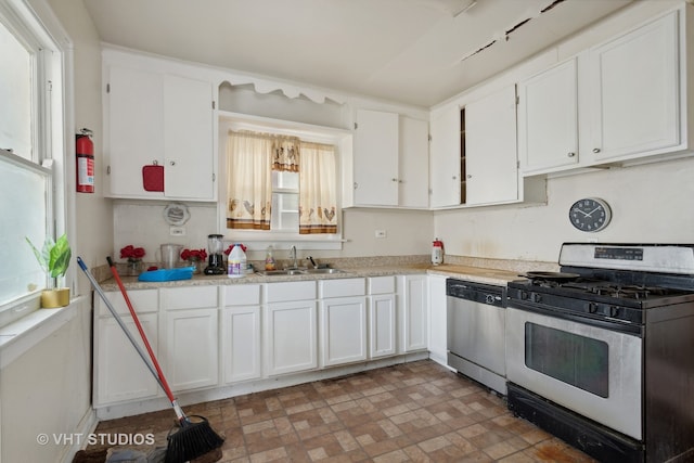 kitchen with stainless steel dishwasher, gas range, and a healthy amount of sunlight