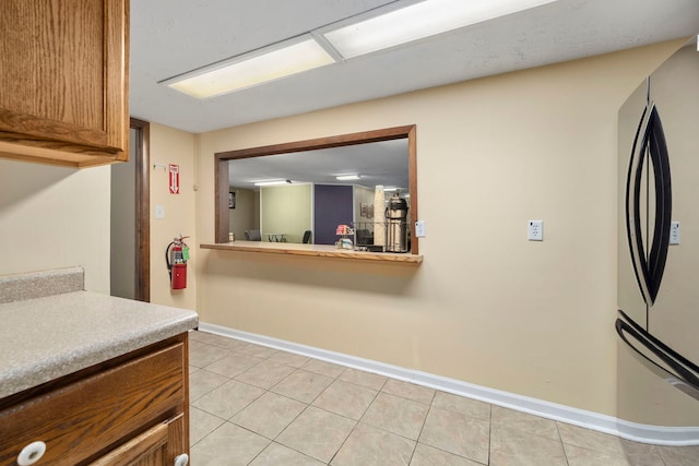 kitchen with stainless steel refrigerator and light tile flooring