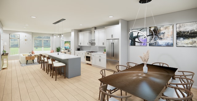 kitchen featuring decorative backsplash, appliances with stainless steel finishes, decorative light fixtures, white cabinets, and a kitchen island