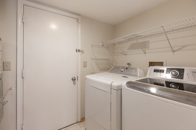 washroom with light tile patterned floors and washer and dryer