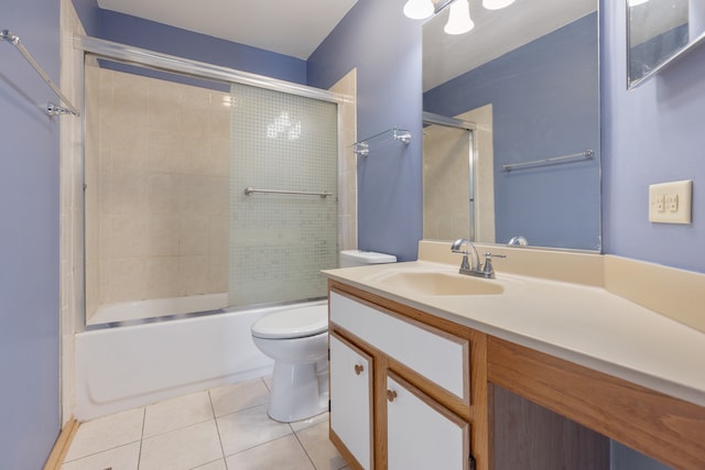 full bathroom featuring toilet, bath / shower combo with glass door, vanity, and tile patterned floors