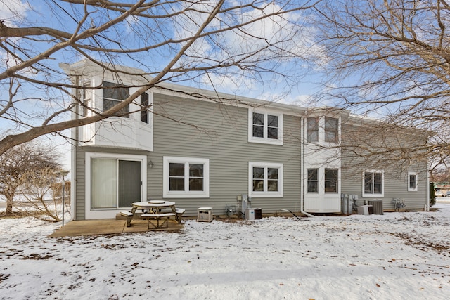 snow covered property with central AC