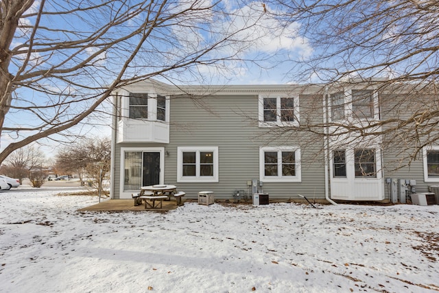 snow covered property with central AC