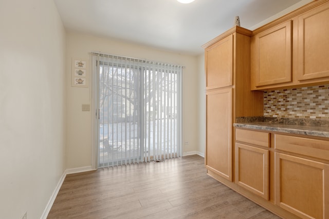 kitchen with light brown cabinets, tasteful backsplash, and light hardwood / wood-style flooring