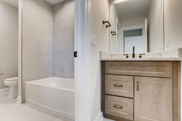 full bathroom with tile floors, toilet, tiled shower / bath combo, and vanity