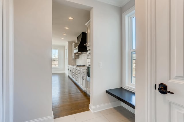 hallway featuring plenty of natural light and light tile floors