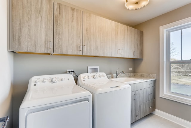 washroom with washer hookup, sink, light tile floors, washing machine and clothes dryer, and cabinets