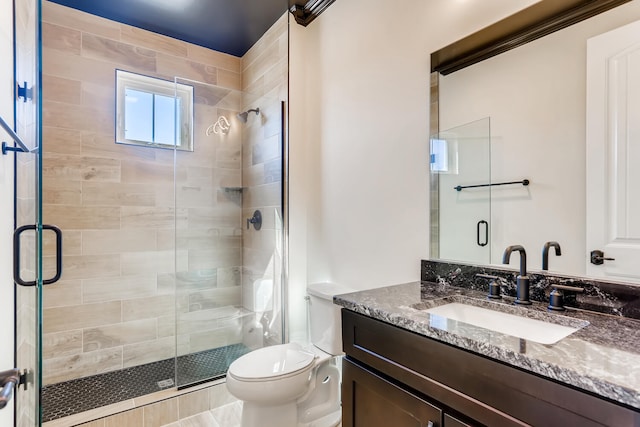 bathroom featuring toilet, an enclosed shower, and vanity