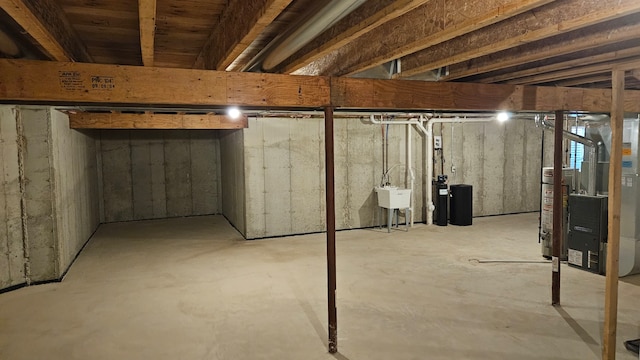 basement with sink, heating unit, and water heater