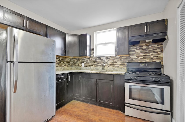 kitchen with sink, tasteful backsplash, light wood-type flooring, and stainless steel appliances