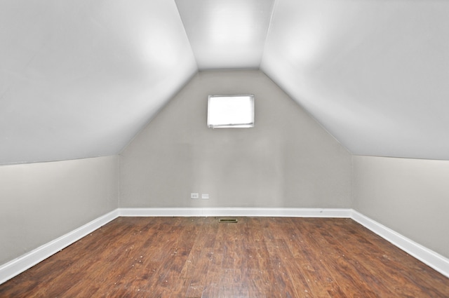 bonus room with hardwood / wood-style flooring and vaulted ceiling