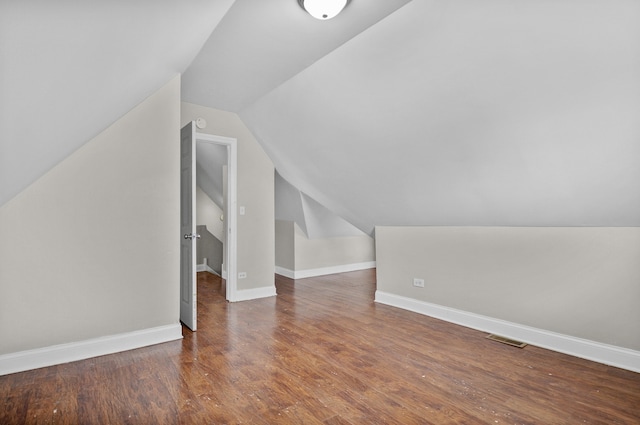 bonus room with vaulted ceiling and dark hardwood / wood-style floors