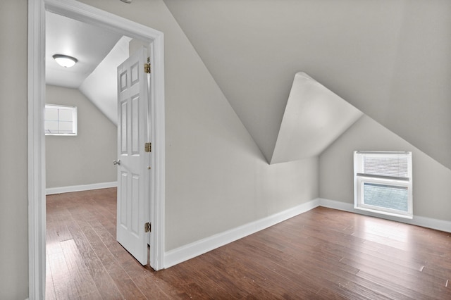 bonus room with plenty of natural light, vaulted ceiling, and hardwood / wood-style floors