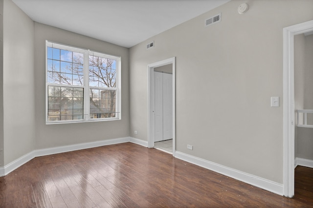 unfurnished room with dark wood-type flooring