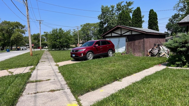 view of yard with a garage and an outbuilding