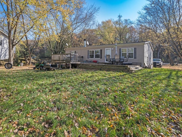 back of house with a deck and a yard