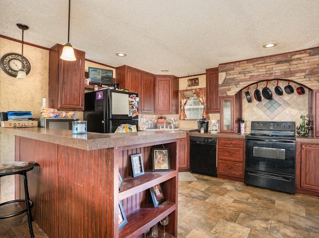 kitchen with pendant lighting, black appliances, a textured ceiling, a kitchen bar, and kitchen peninsula