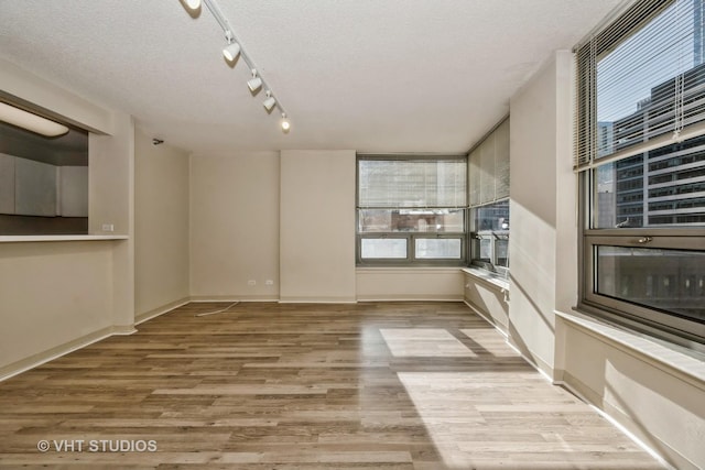 unfurnished living room featuring light hardwood / wood-style floors and a textured ceiling