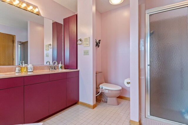 1210 Lakeridge Ct, Danville, IL 61832 - full bath with double vanity, toilet, a shower stall, tile patterned floors, and baseboards