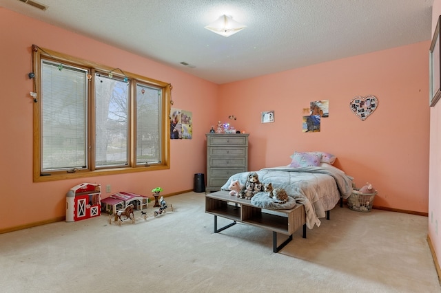 bedroom with light colored carpet and a textured ceiling