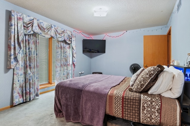 bedroom featuring light carpet and a textured ceiling