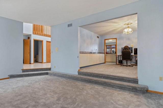 carpeted empty room with a chandelier