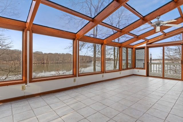 unfurnished sunroom featuring a skylight, plenty of natural light, ceiling fan, and a water view