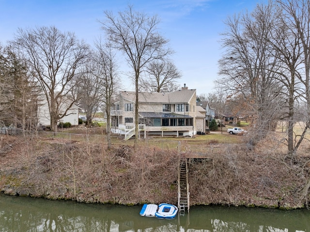 back of property featuring a water view and a balcony