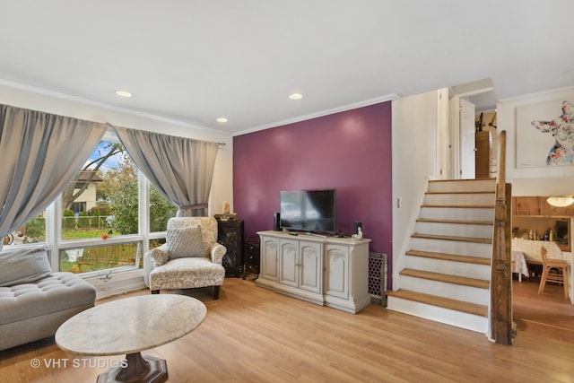 living room featuring ornamental molding and light hardwood / wood-style floors