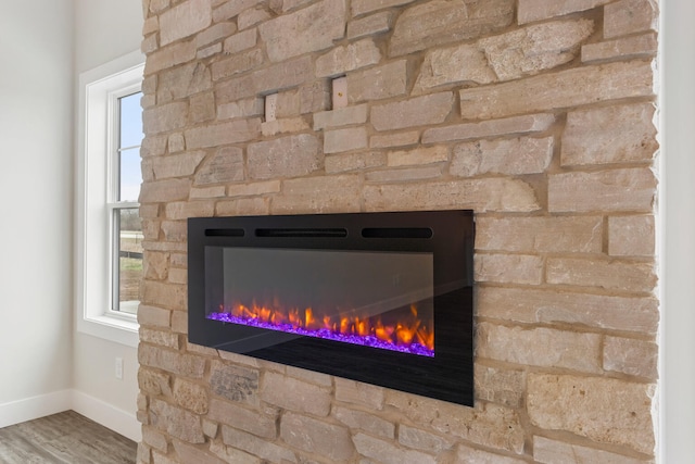 interior details with hardwood / wood-style floors and a stone fireplace