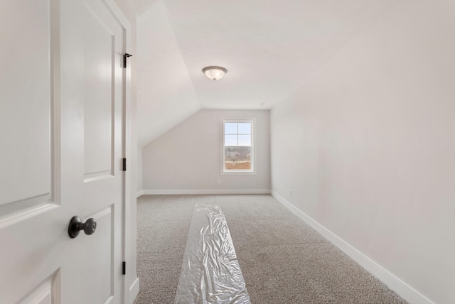 bonus room with vaulted ceiling and carpet floors