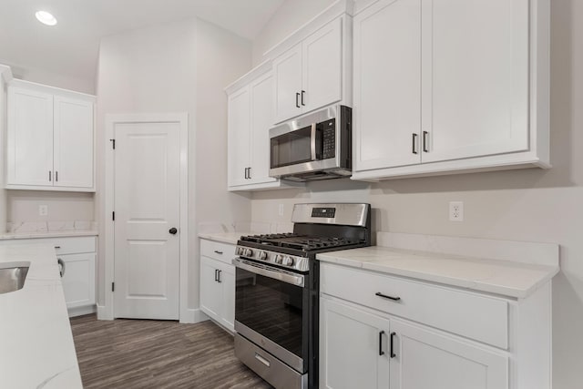 kitchen with white cabinets, stainless steel appliances, dark hardwood / wood-style floors, and light stone countertops