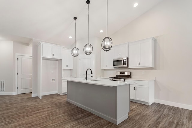 kitchen with dark hardwood / wood-style flooring, stainless steel appliances, white cabinetry, and a center island with sink