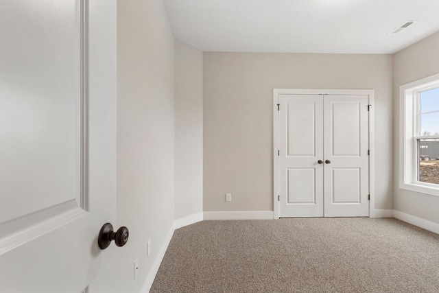 unfurnished bedroom featuring carpet flooring and a closet